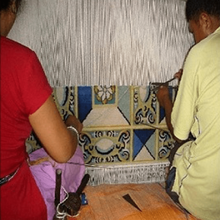 The rug in progress at our factory, where it is hand knotted by our artisan weavers.
